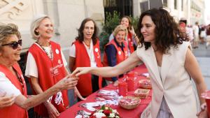 La presidenta Isabel Díaz Ayuso en una mesa informativa de Cáritas Diocesana