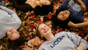 Adolescentes tumbados sobre hojas de otoño