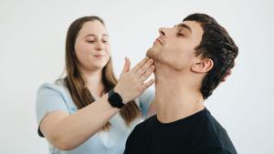 Profesional sanitaria atendiendo a un paciente Profesional sanitaria ayudando a hacer ejercicios de cuello