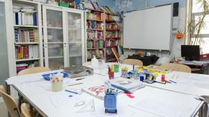 Material escolar sobre una mesa de un aula 