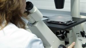 Científica analizando muestra con un microscopio 