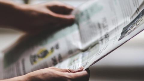 Manos sosteniendo un periódico