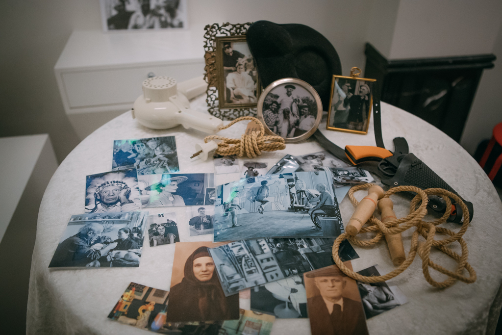 Mesa camilla con fotografías antiguas desordenadas sobre ella