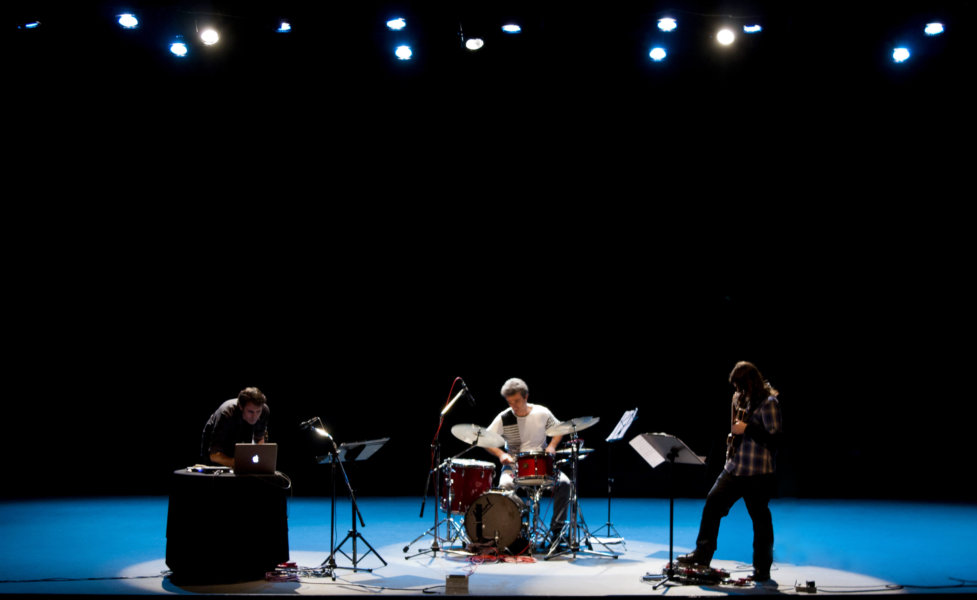 3 musicos con sus instrumentos en el escenario