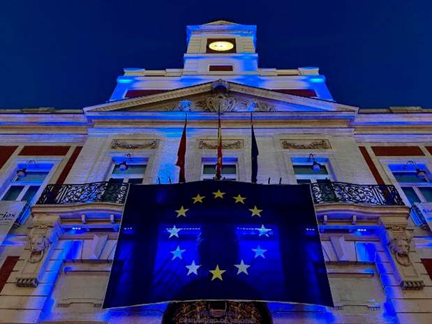 Fachada de la Real Casa de Correos iluminada con los colores de la UE