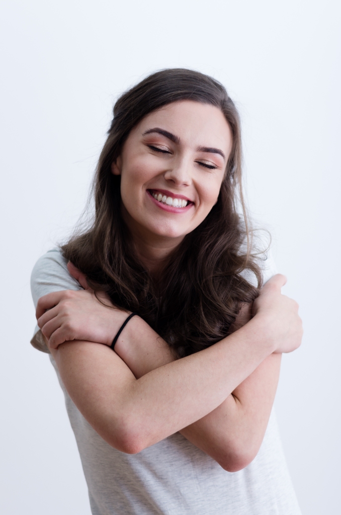 chica feliz abrazándose a sí misma