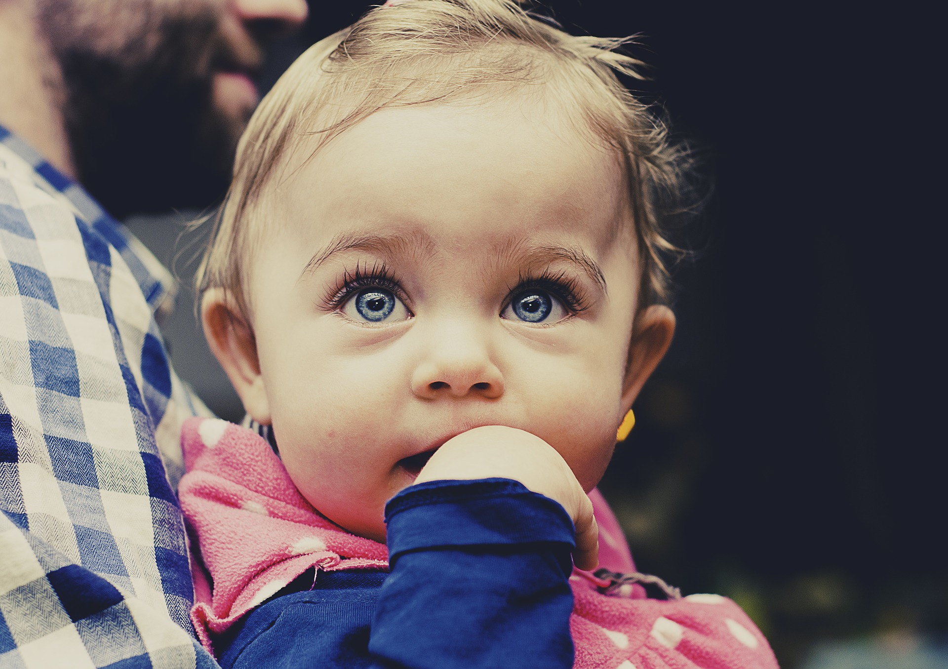 Niña de ojos azules en brazos de su padre