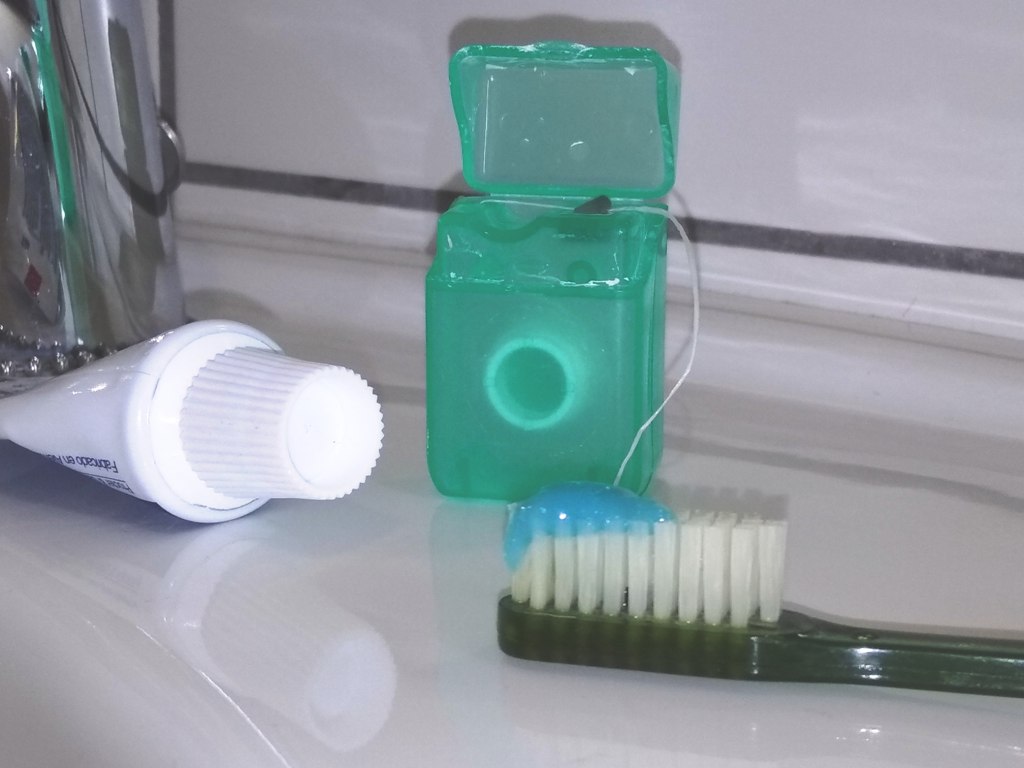 Cepillo con pasta de dientes e hilo dental