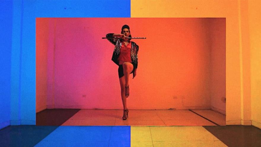 Una persona entre colores bailando con una flauta