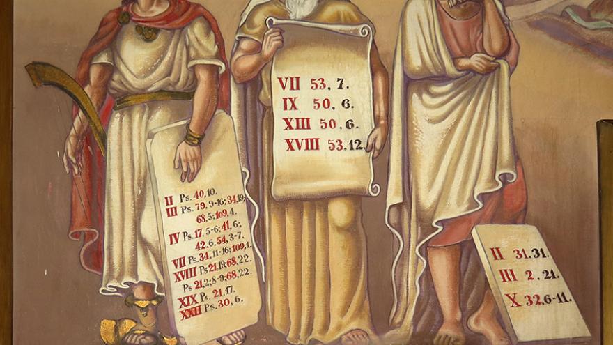 Pintura mural representando tres personajes masculinos togados sobre un pedestal
