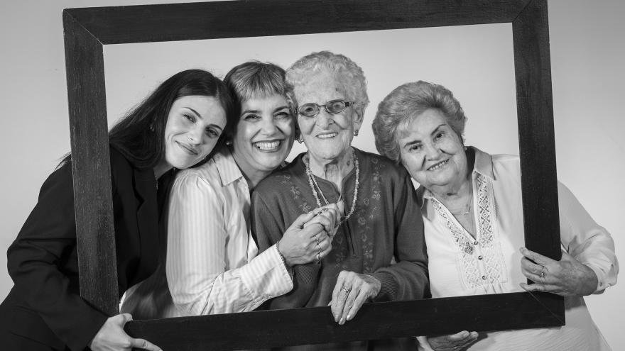 Cuatro mujeres de distintas edades sujetan un marco