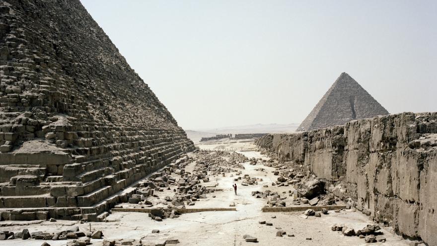 Camino desértico con rocas entre pirámides