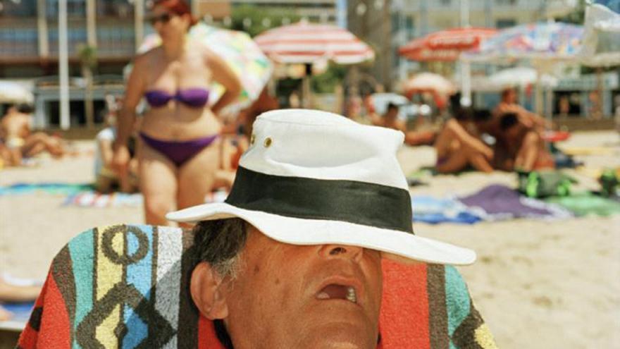 Hombre dormido y cubierto con sombrero en la playa