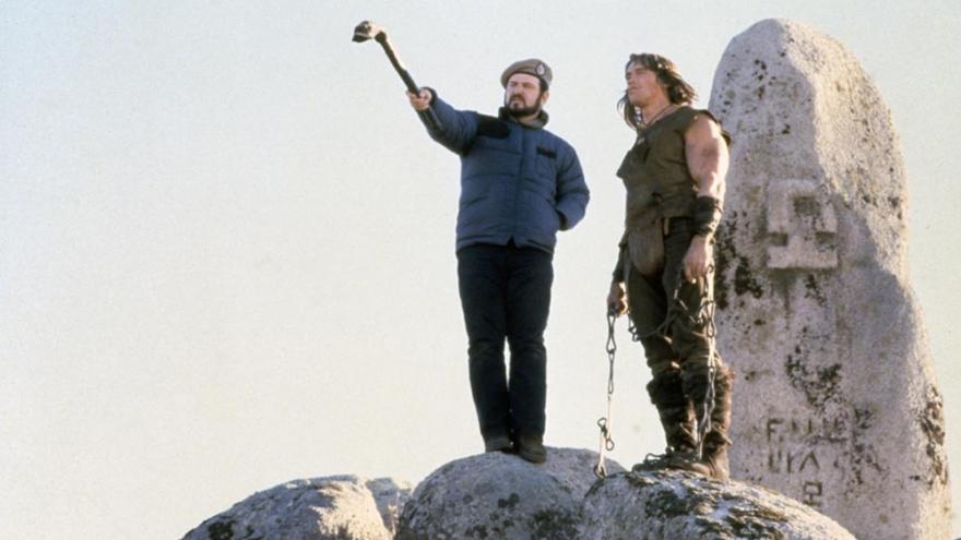 Dos hombres en lo alto de unas rocas, uno de ellos señala a lo lejos
