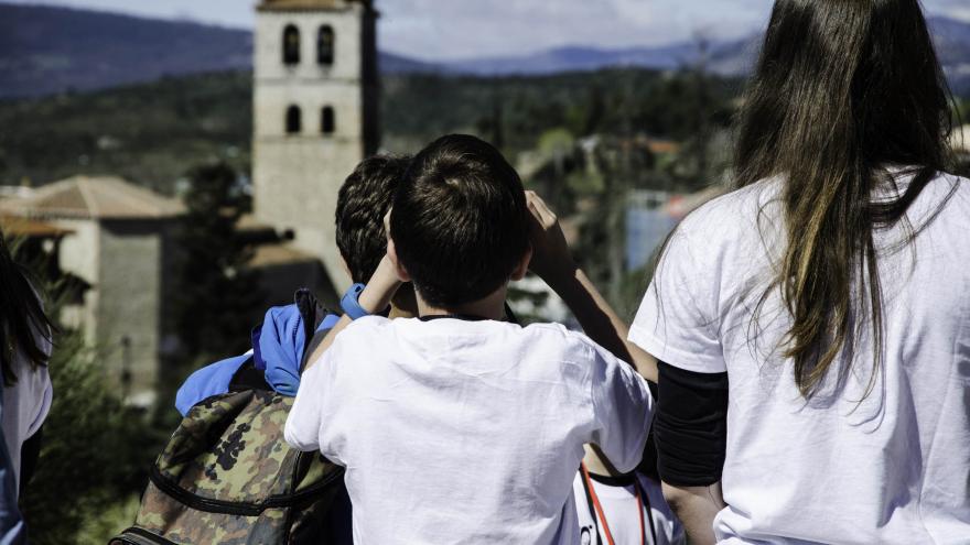 Niños y niñas con prismáticos viendo el pueblo de Manzanares El Real