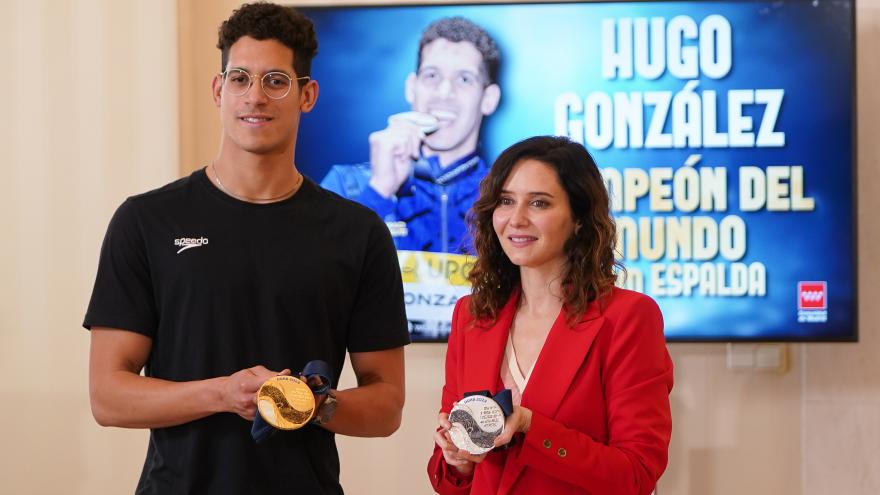 La presidenta entregando el trofeo al nadador