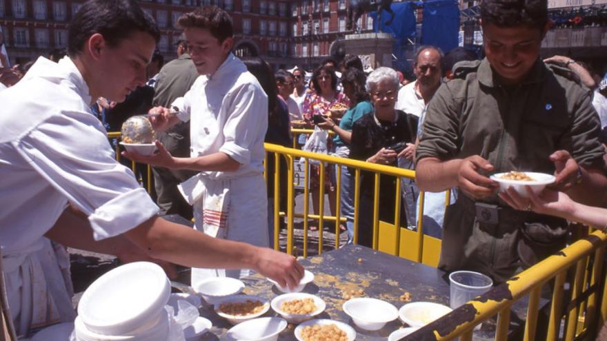 Cocido en la plaza. Fondo Madrileños. ARCM imagen de reparto de cocido en una plaza