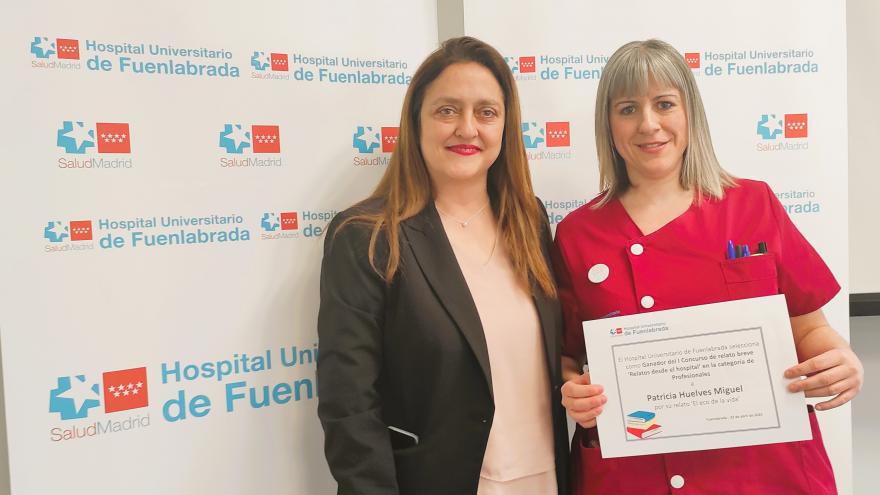 Dos mujeres y una de ellas sostiene un diploma