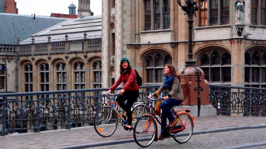 Dos chicas pasean en bici por una ciudad
