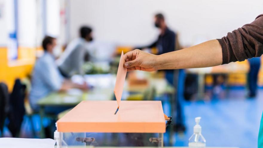 Mujer depositando su voto en una urna