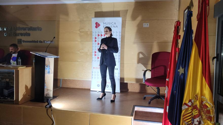 Mujer cantando ante un auditorio
