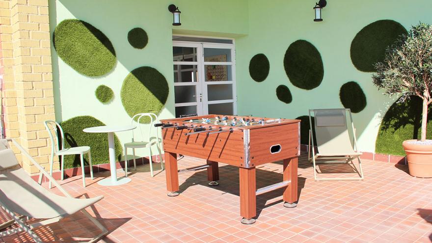 Terraza exterior con futbolín y jardín vertical
