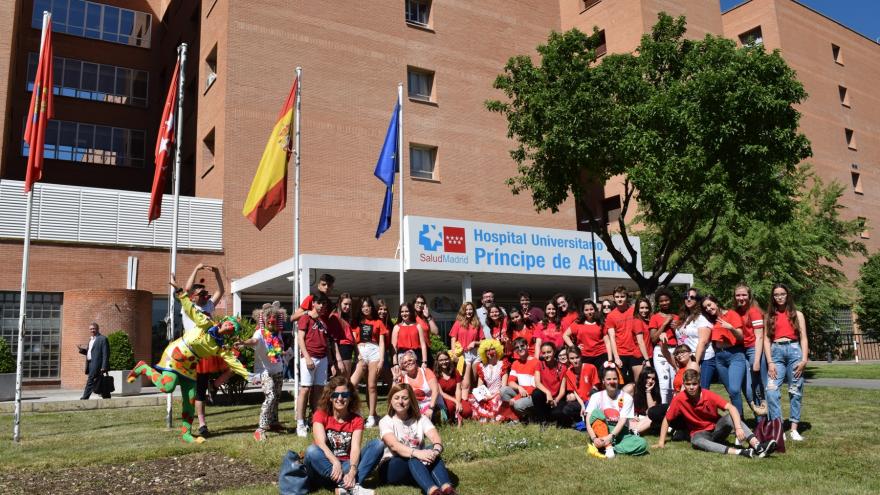 Alumnos y profesores del IES Cardenal Cisneros posan a las puertas del Hospital en compañía de los payasos de Barabú y personal de la Bolsa de Voluntariado del Ayuntamiento de Alcalá