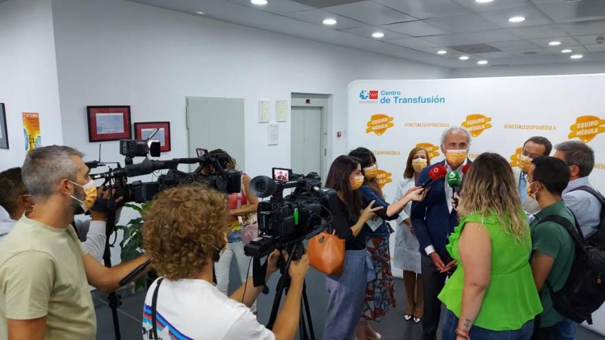 Periodistas de pie grabando declaraciones de una autoridad sanitaria