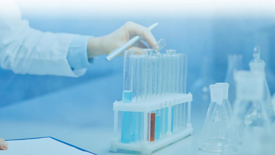 Sistema de vigilancia de coronavirus en aguas residuales mano manipulando tubos de ensayo en un laboratorio
