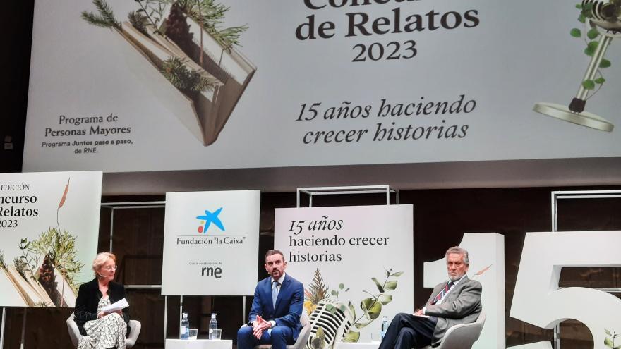 Tres personas en un escenario sentadas