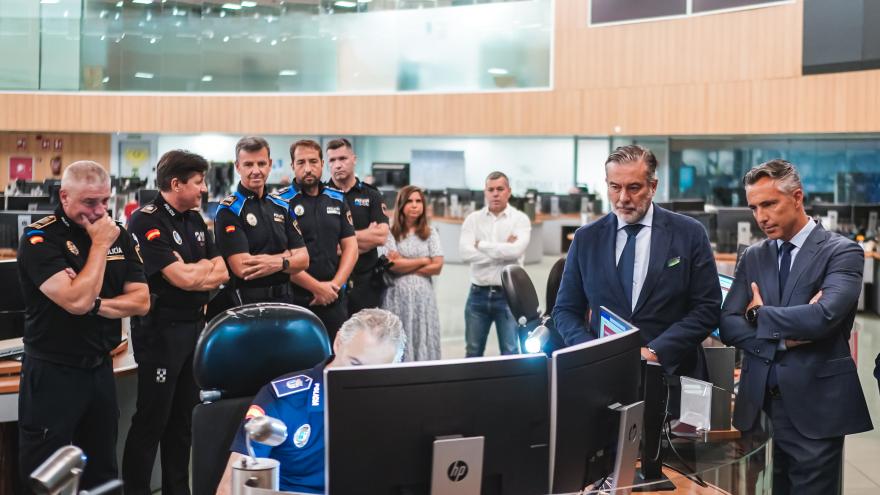 El consejero Enrique López observa la labor de los policías ante un ordenador