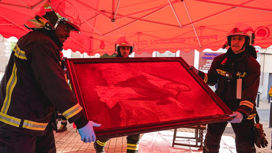 Los bomberos sacando un cuadro para su resguardo