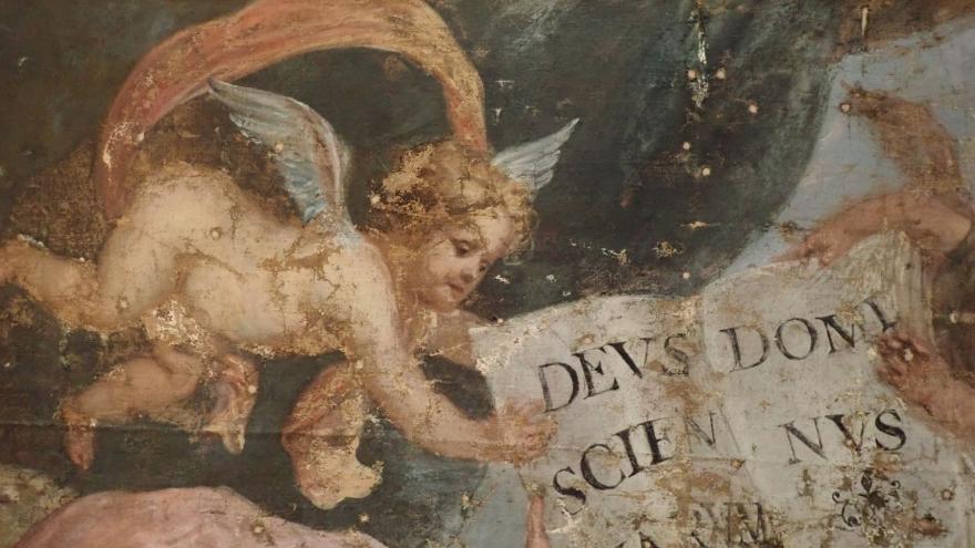 Imagen en detalle de una pintura representando a un ángel portando un cartel