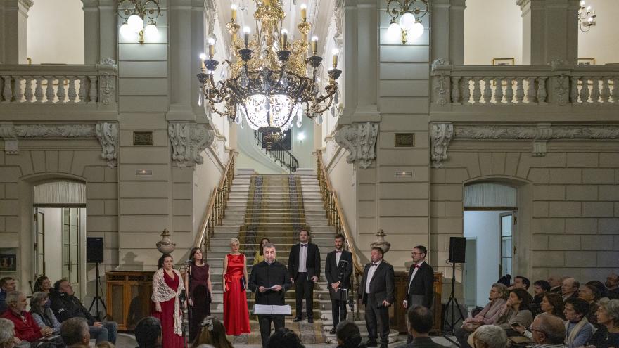 choir and director in front of the public inside a palace