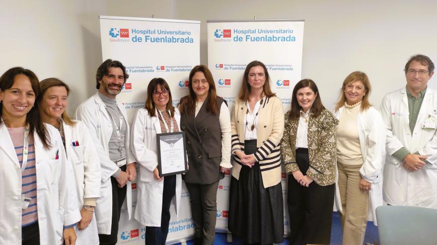 Cinco personas posan junto a un certificado