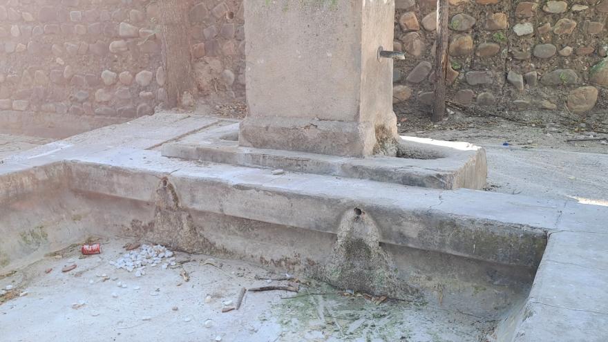 caños de metal y pileta de fuente de piedra