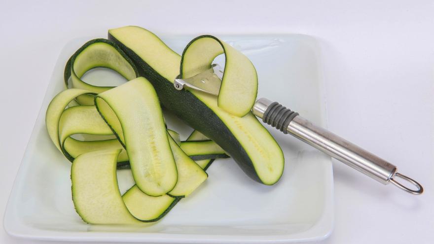 calabacín en un plato con un pelador