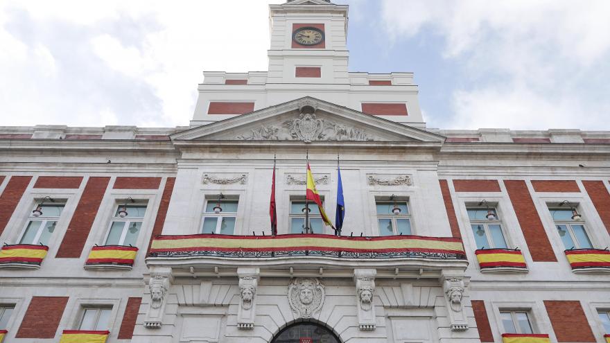Fachada de la Real Casa de Correos decorada con la bandera española