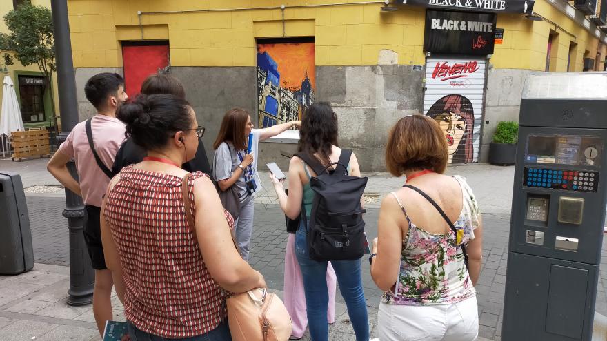 Personas observando la fachada del bar Black White en Chueca
