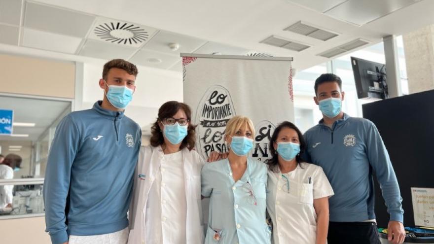 Soccer players together with health personnel in a hospital