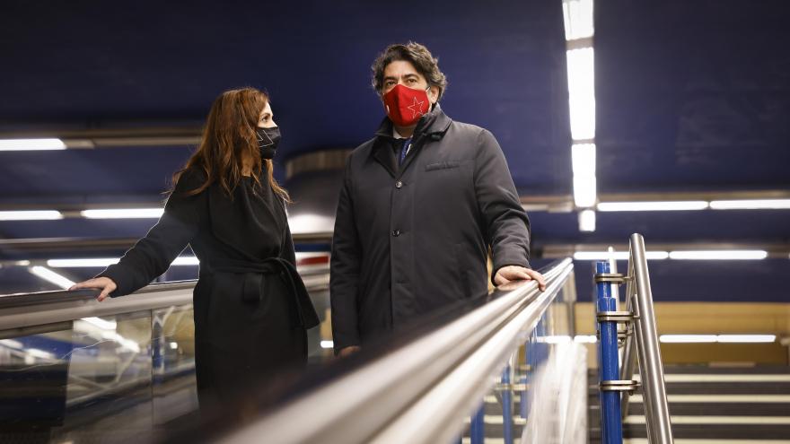 El consejero junto a la responsable de metro bajando por unas escaleras mecánicas
