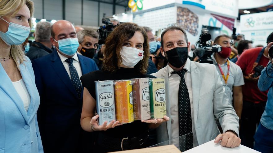 La presidenta sujetando varias latas de productos de Madrid