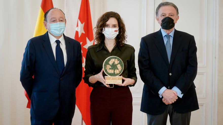 La presidenta sujetando el premio junto a los representantes de la asociación