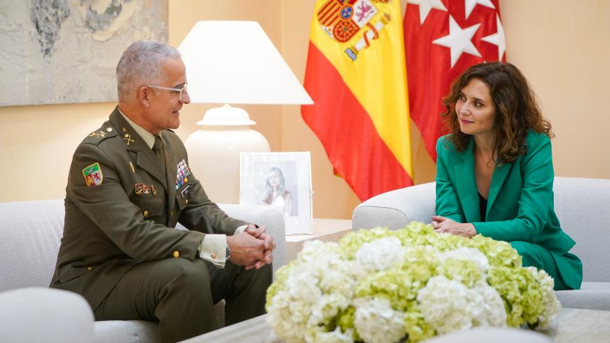 La presidenta sentada hablando con el comandante