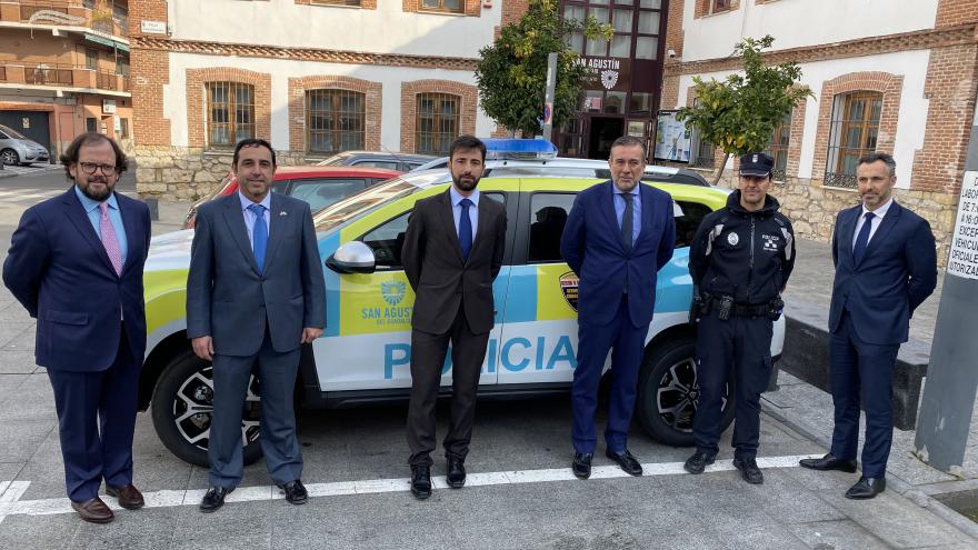 Posado delante de un coche de polícía consejero y agentes
