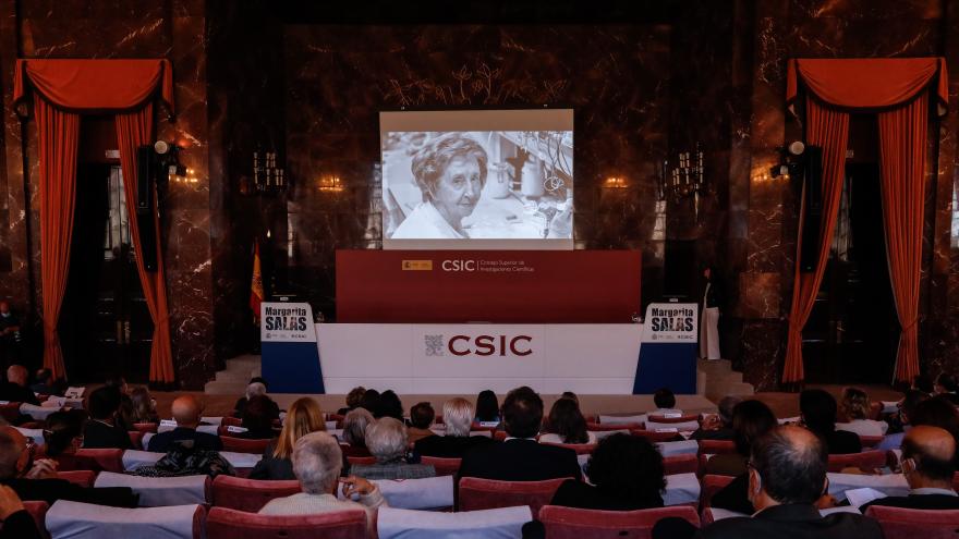 Panorámica general del acto mientras se proyecta un vídeo de Margarita Salas