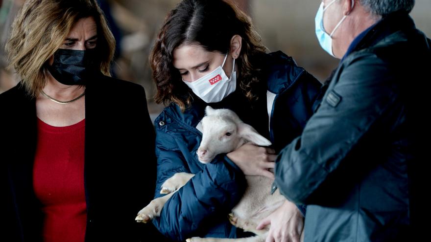La presidenta con una oveja en los brazos visitando la finca