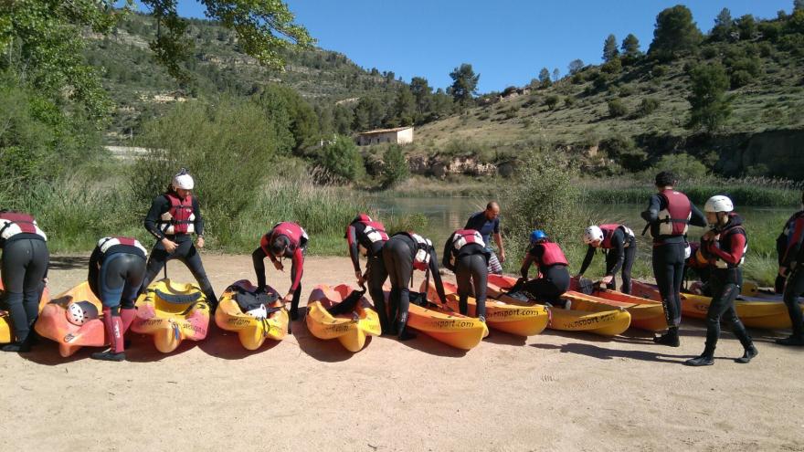 Grupo de jóvenes equipados y con piraguas