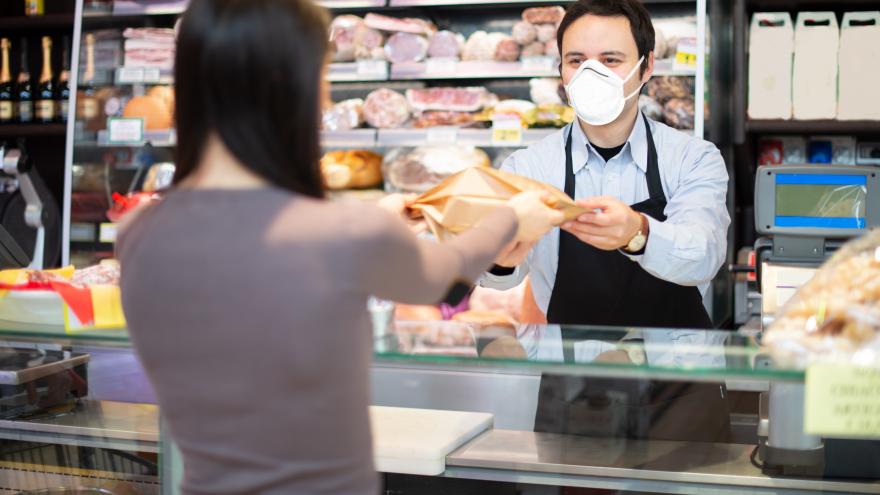 Dependiente de supermercado dando la compra a una clienta