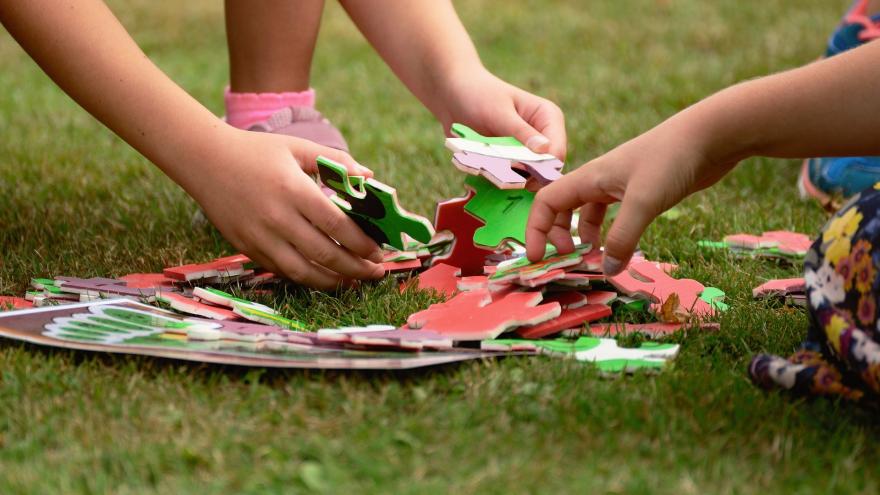 Manos de niños con piezas de puzzle